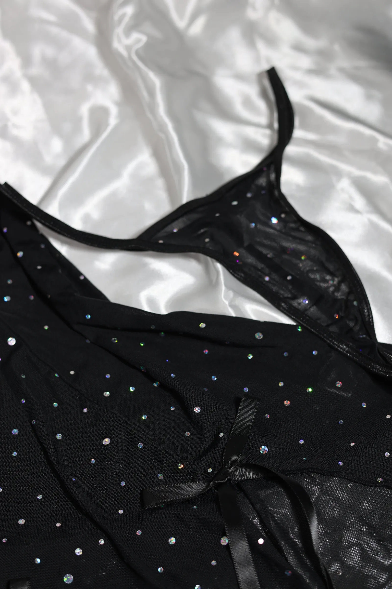 Detalle de un babydoll negro con pedrería